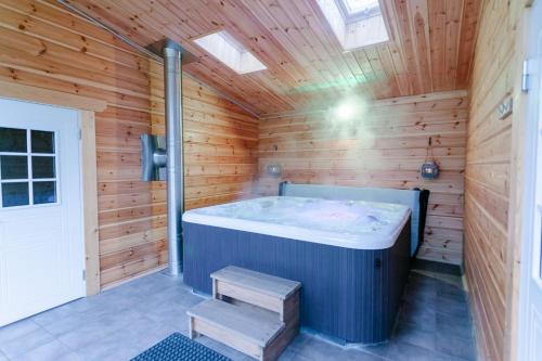 una sauna con una gran bañera en un techo de madera en Baza otdiha Lesnaya Obitel, en Roshchino