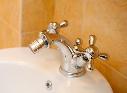 a bathroom sink with a brass faucet at Residenze L'Uncinaia Holiday House in Perugia