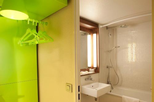 baño verde con lavabo y ducha en Campanile Clermont-Ferrand ~ Riom, en Riom