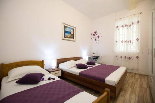 - 2 lits dans une chambre de couleur violette et blanche dans l'établissement Apartment La Mirage, à Dubrovnik