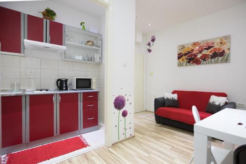 a kitchen and a living room with a red couch at Apartment La Mirage in Dubrovnik
