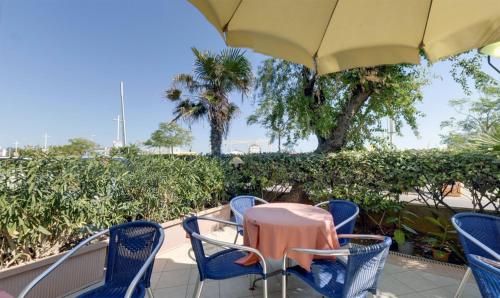a table and chairs with an umbrella on a patio at Hotel Margareth in Riccione