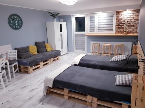 sala de estar con 2 camas y sofá en Apartament Panorama, en Kielce