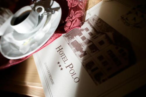 a table with a book and a pair of scissors at Hotel Al Polo in Ziano di Fiemme