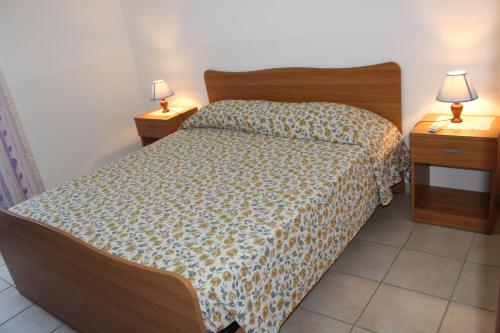 トッレ・スーダにあるVilletta/Appartamento Mahia1のベッドルーム1室(ベッド1台、ランプ付きのナイトスタンド2台付)