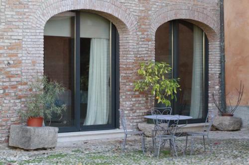 una mesa y sillas frente a una ventana en Borgo Archinto, en Robecco sul Naviglio