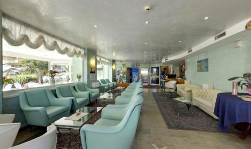 a waiting room with blue chairs and couches at Hotel Margareth in Riccione