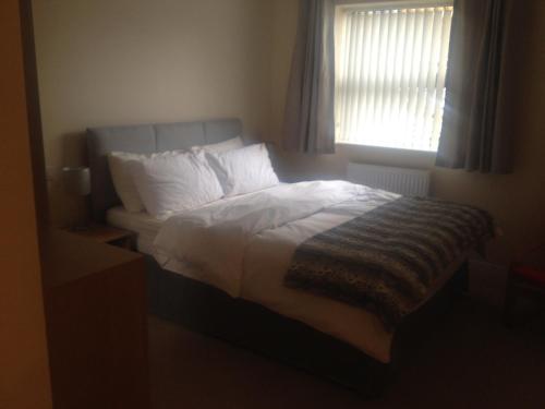 a bedroom with a large bed with a window at Stockley Near Heathrow in Yiewsley