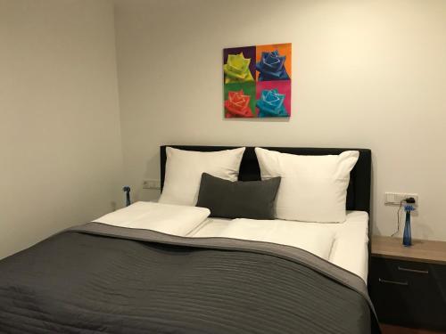 a bedroom with a bed with a painting above it at Pension Scheiber Hof in Neunkirchen