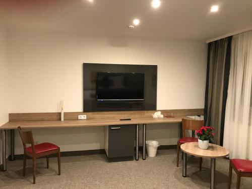 a room with a desk with a tv on the wall at Pension Scheiber Hof in Neunkirchen