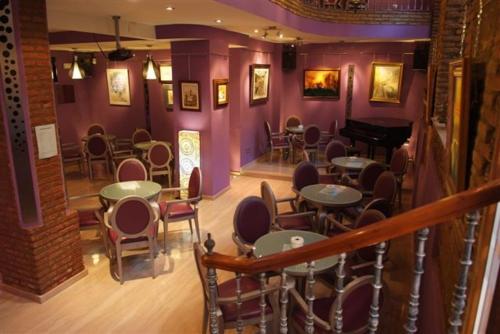a restaurant with tables and chairs and a piano at Hotel Palacio de Oñate in Guadix