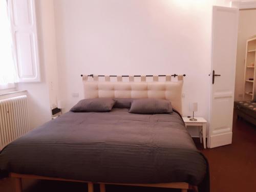 a bedroom with a large bed with a white headboard at Il Cortile in Iesi