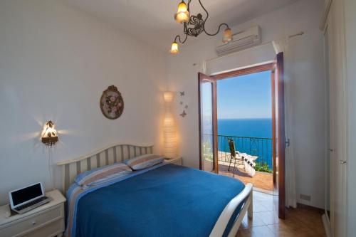 a bedroom with a bed and a view of the ocean at Mon Amour Praiano in Praiano