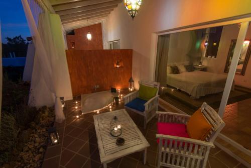 a balcony with a room with a bed and a table at Herdade do Amarelo Nature & Spa in Vila Nova de Milfontes