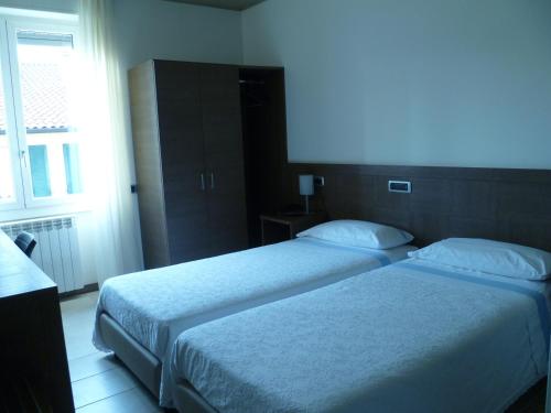 a hotel room with two beds and a window at Albergo Sole in Mariano Comense