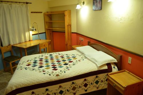 un letto in una camera con copriletto a scacchiera. di Hostal Pachamama a Sucre