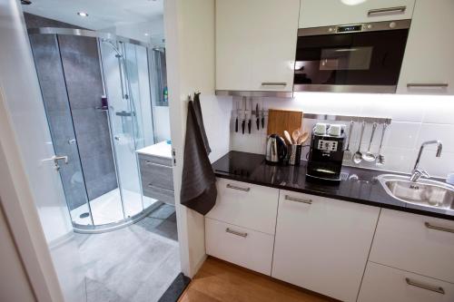 a white kitchen with a shower and a sink at Central & Quiet Canal Apartment in Amsterdam