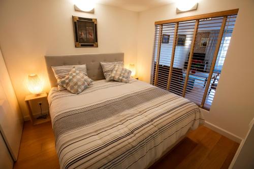 a bedroom with a large bed with a window at Central & Quiet Canal Apartment in Amsterdam