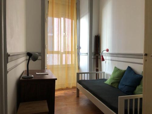 リスボンにあるEncantadora Casa do Limoeiroのベッドルーム1室(ベッド1台、テーブル、窓付)