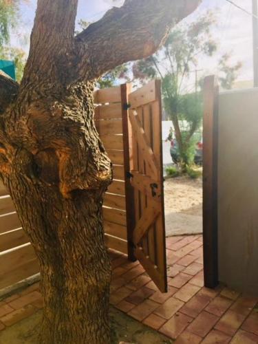 a door to a tree next to a fence at El Tamarisco in Puerto Pirámides