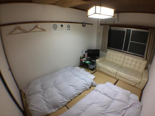 a small room with two beds and a couch at Kenroku Haitsu 203 in Kanazawa