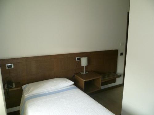 a bedroom with a bed and a table with a lamp at Albergo Sole in Mariano Comense