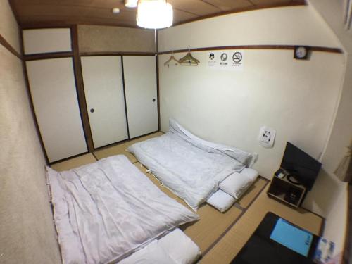 Una pequeña habitación con dos camas. en Kenroku Haitsu 303, en Kanazawa