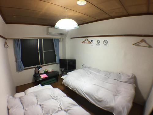Un dormitorio con dos camas blancas y una ventana. en Kenroku Haitsu 305, en Kanazawa