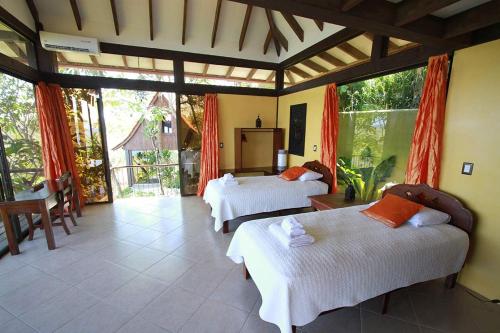 a bedroom with two beds and a large window at Anamaya Resort in Montezuma