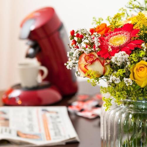 a vase with flowers in it on a table at Hotel Verhoeven in Uden