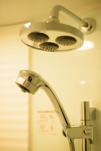 a bathroom sink with a light on top of it at Guesthouse Kintoto in Kanazawa