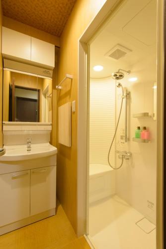a bathroom with a shower and a sink at Guesthouse Kintoto in Kanazawa