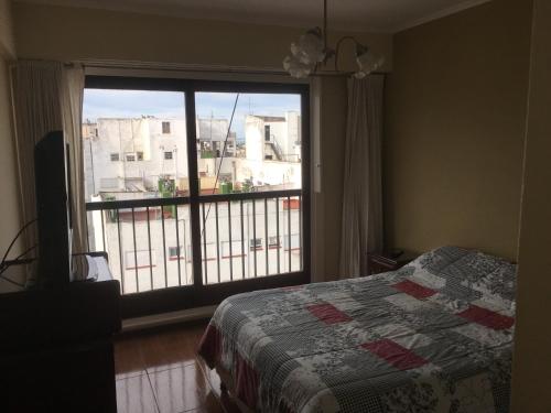 1 dormitorio con cama y ventana grande en Departamento 2 ambientes Mar del Plata en Mar del Plata