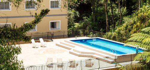 a swimming pool with chairs next to a building at Sky Serra Hotel in Gramado