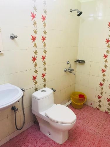 a bathroom with a toilet and a sink at Moon Valley Cottage in Kovalam