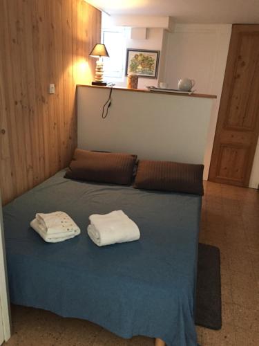 une chambre avec un lit avec deux serviettes dessus dans l'établissement Le Charme, à Wimereux