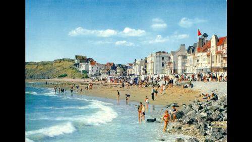 un grupo de personas en una playa cerca del océano en Le Bellevue, en Wimereux