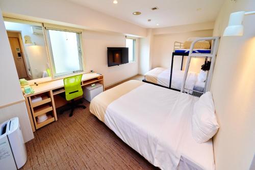 a bedroom with a bed and a desk with a mirror at Super Hotel Ogaki Ekimae in Ogaki