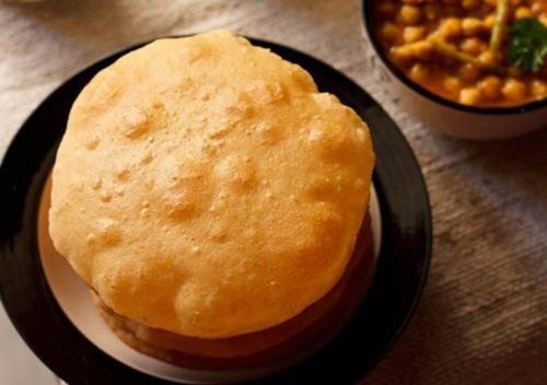 a black plate with a sandwich and a bowl of beans at Viceroy Inn Dehradun in Dehradun