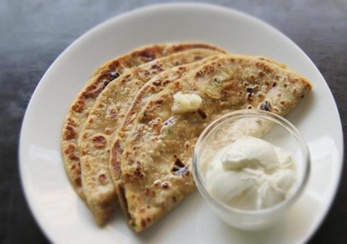 a white plate with two slices of pancakes and ice cream at Viceroy Inn Dehradun in Dehradun