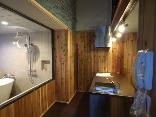 a bathroom with a sink and a shower at Pension Tomato in Hakuba