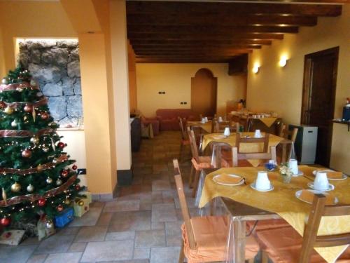 a christmas tree in a restaurant with wooden tables at Aurora dell'Etna in Zafferana Etnea