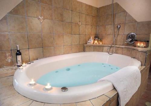 a bath tub with a bottle of wine in a bathroom at Etzel Tami Hospitality in Neot Golan