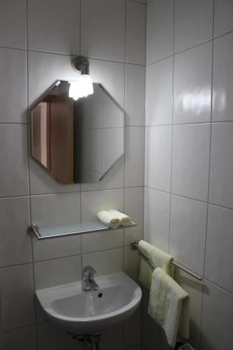 a bathroom with a sink and a mirror and towels at Landgasthof Weberhans in Harburg