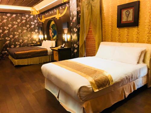 a hotel room with two beds and a table with a lamp at Hakodate Motel in Kaohsiung