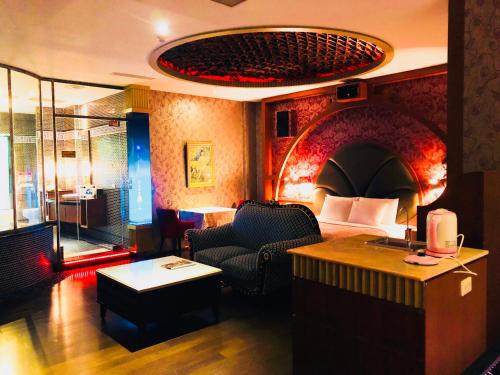 a hotel room with a bed and a chair and a table at Hakodate Motel in Kaohsiung