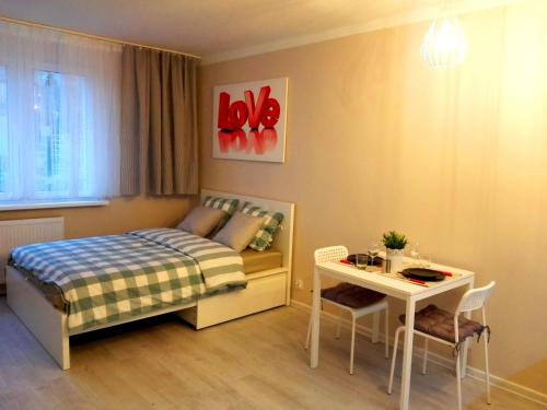 グディニャにあるVanilly Apartament Centrum Gdyniaの小さなベッドルーム(ベッド1台、テーブル付)
