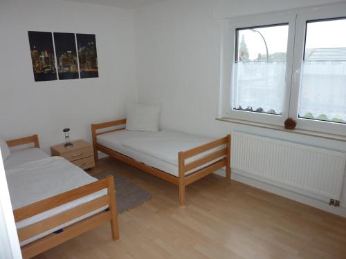 - une chambre avec 2 lits et 2 fenêtres dans l'établissement Ferienwohnung Landwehr, à Großostheim