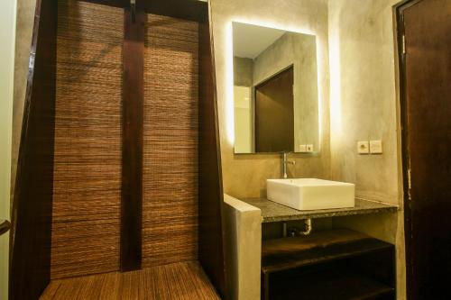 a bathroom with a sink and a mirror at Watu Agung Guest House in Borobudur