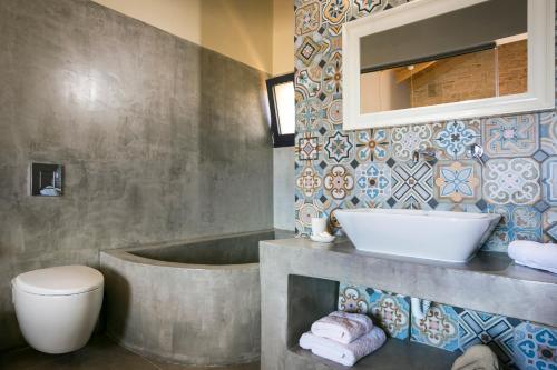 a bathroom with a tub and a toilet and a sink at Kaminia Blu in Ratzaklíon